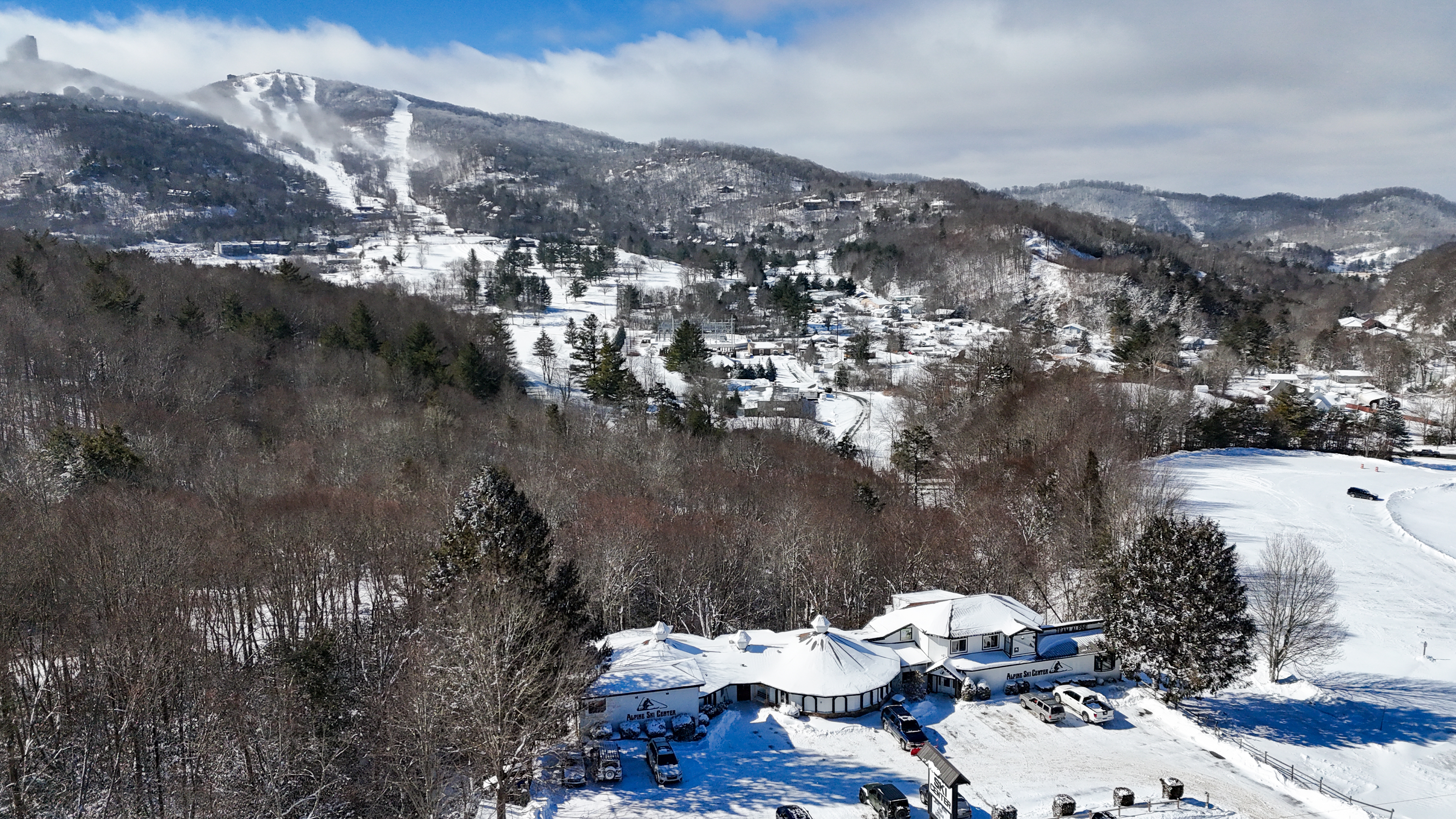 Aerial view of Alpine Ski Center's Banner Elk store with Beech Mountain's snow-covered ski slopes in the background